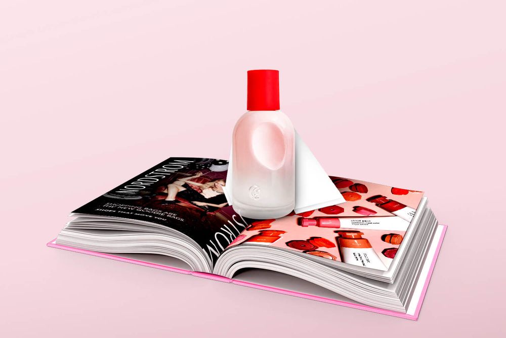 A bottle of Glossier perfume popping out of a magazine