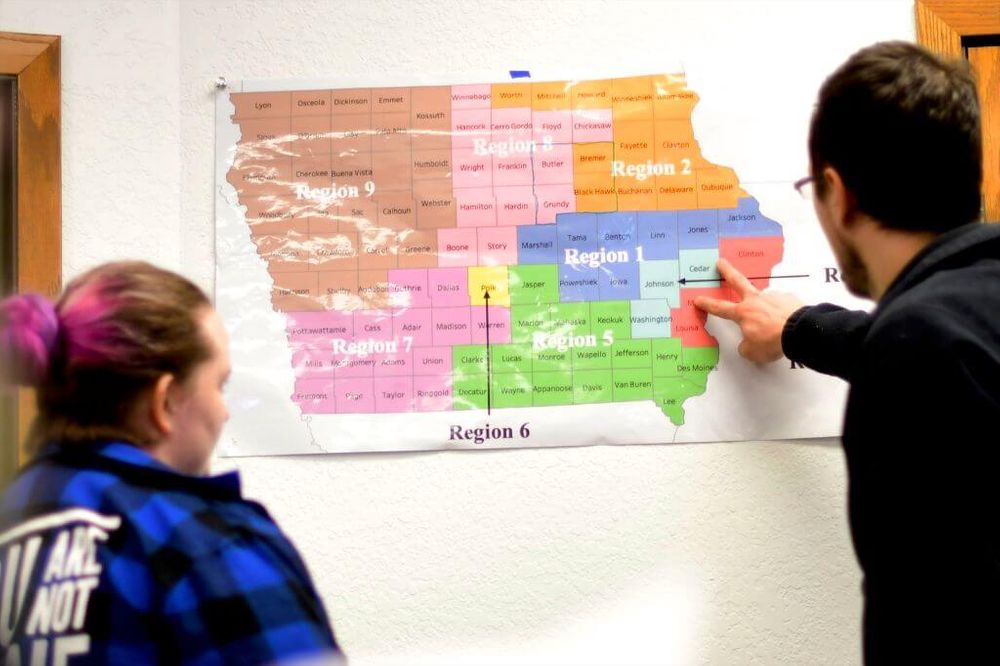 Two people looking at an election map of Iowa 