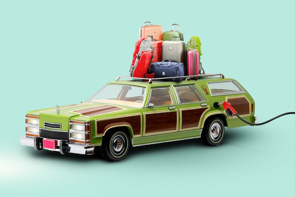 station wagon with suitcases on top being filled with gas