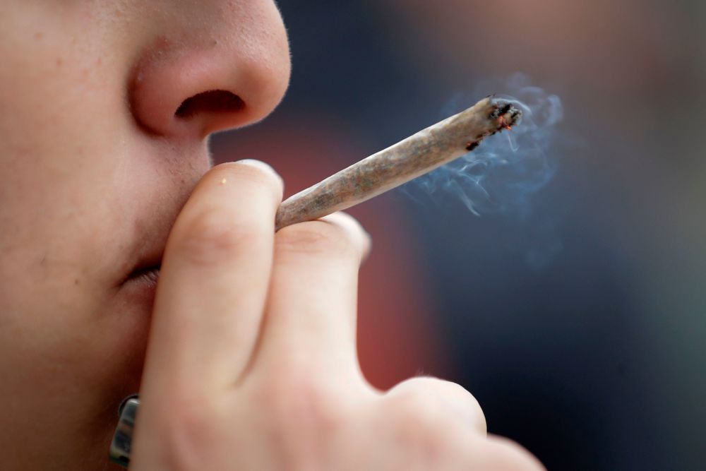 A man smokes a joint during a demonstration for the decriminalization of...