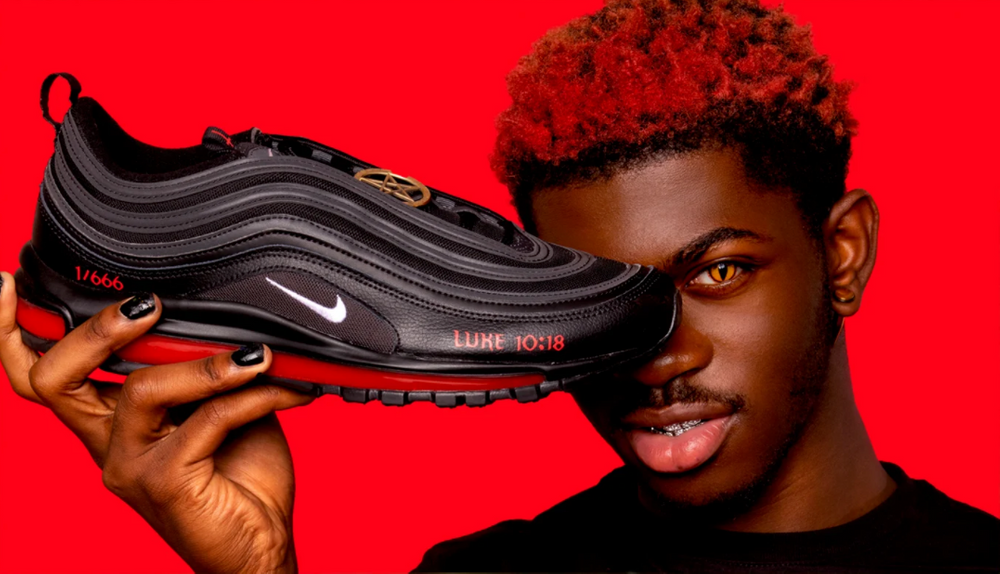 Singer Lil Nas X holds "Satan" Nikes in front of face
