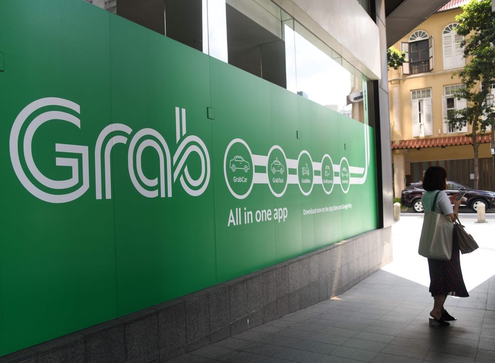 A woman stands outside the Grab transport office in Singapore on June 13...