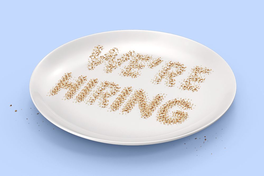 An illustration of a white plate on a baby blue background. Rice grains are sprinkled on the plate, forming the words 