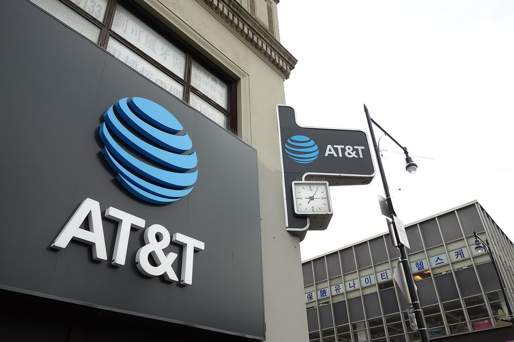 A photograph of the AT&T logo and name on a sign attached to the front of a building.