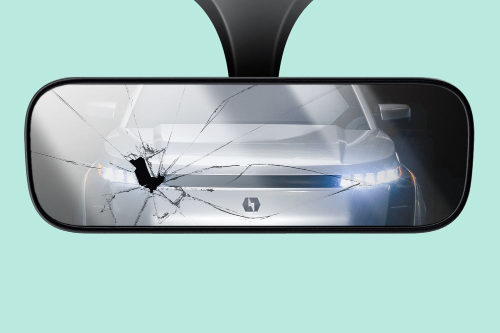 An illustration of a cracked rearview car mirror in front of a mint background. Reflected in the mirror is a silver car with the Lordstown Motors' lightning logo on its hood.