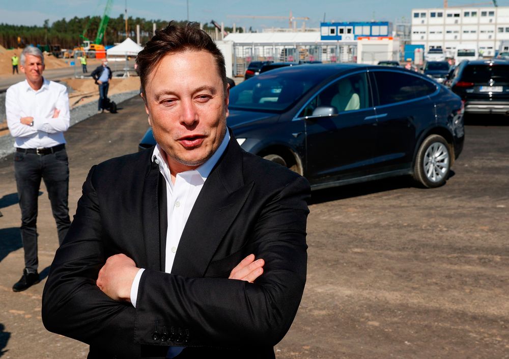 Tesla CEO Elon Musk talks to media as he arrives to visit the constructi...