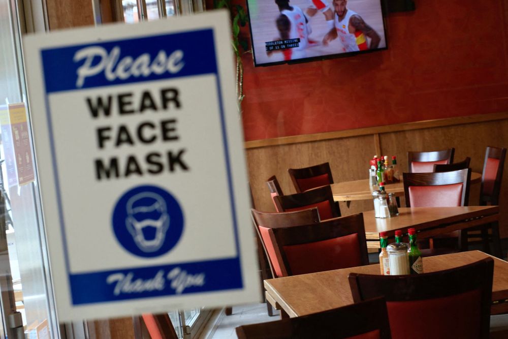 A sign asking patrons to wear a face mask is seen at the entrance of a r...