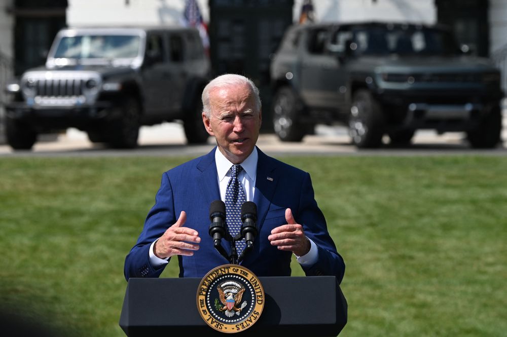 Electric vehicules are seen in the background as US President Joe Biden ...