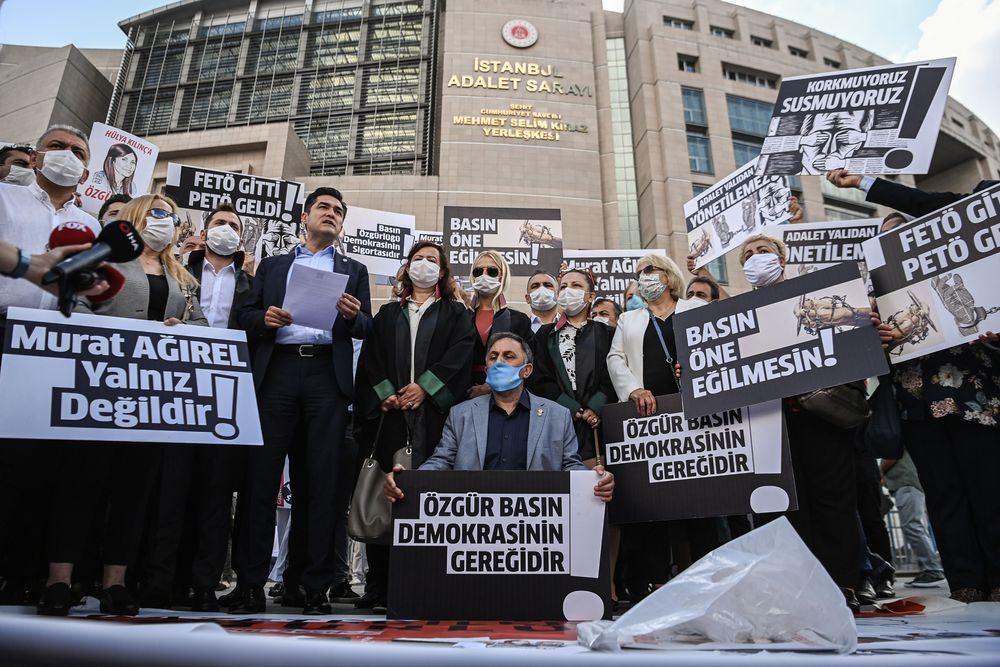 Demonstrators hold posters reading "Journalism is the insurance of democ...