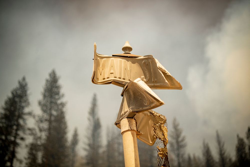 TOPSHOT - A fire-damaged street sign marks Main Street in a decimated do...