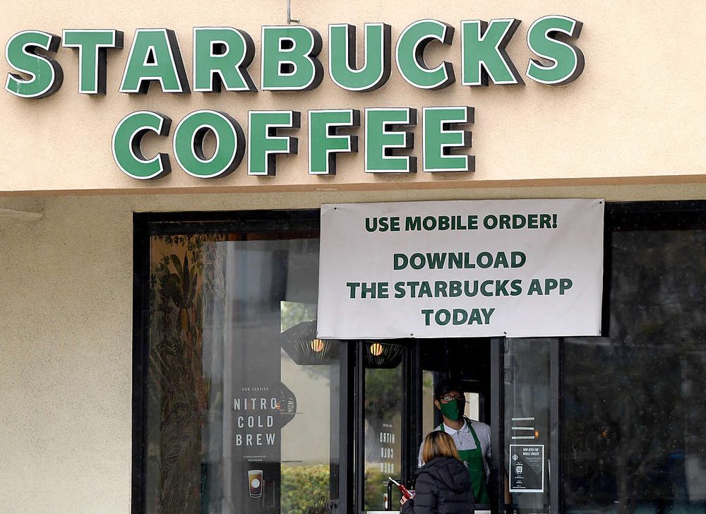 SOUTH PASADENA, CA - APRIL 07:  A Starbucks employee serves a walk-up cu...