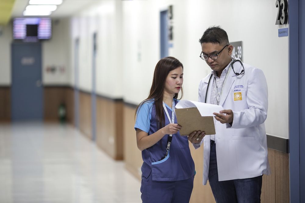 Photo of a doctor and nurse looking at a patient chart