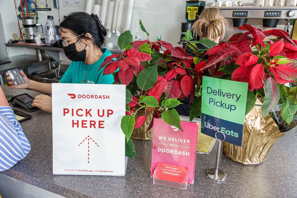 Florida, Miami, restaurant cashier with signs for food delivery services...