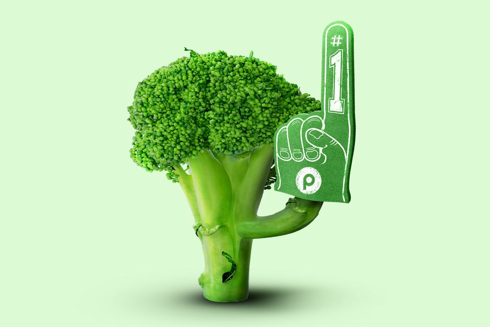 A piece of broccoli holding a Publix no.1 fan sign