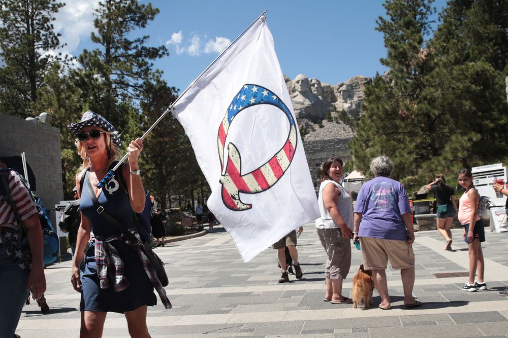 A Trump supporter holding a QAnon flag