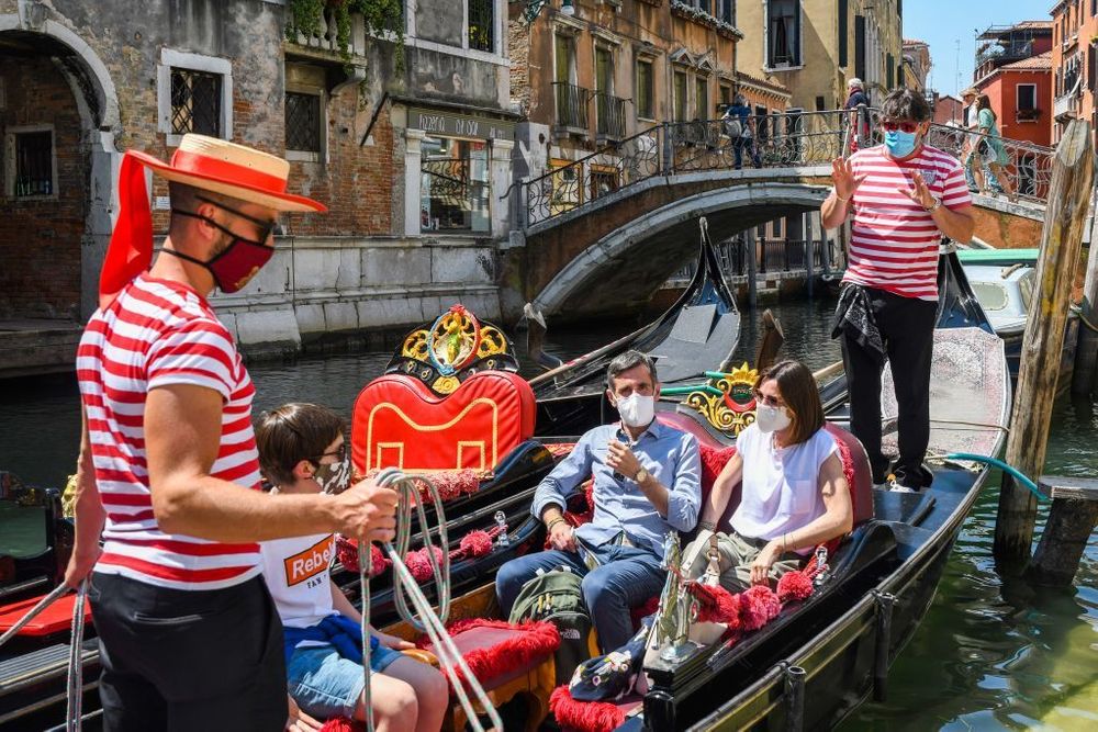 Men wearing stirped shirts taking tourists on a Euopean boat tour