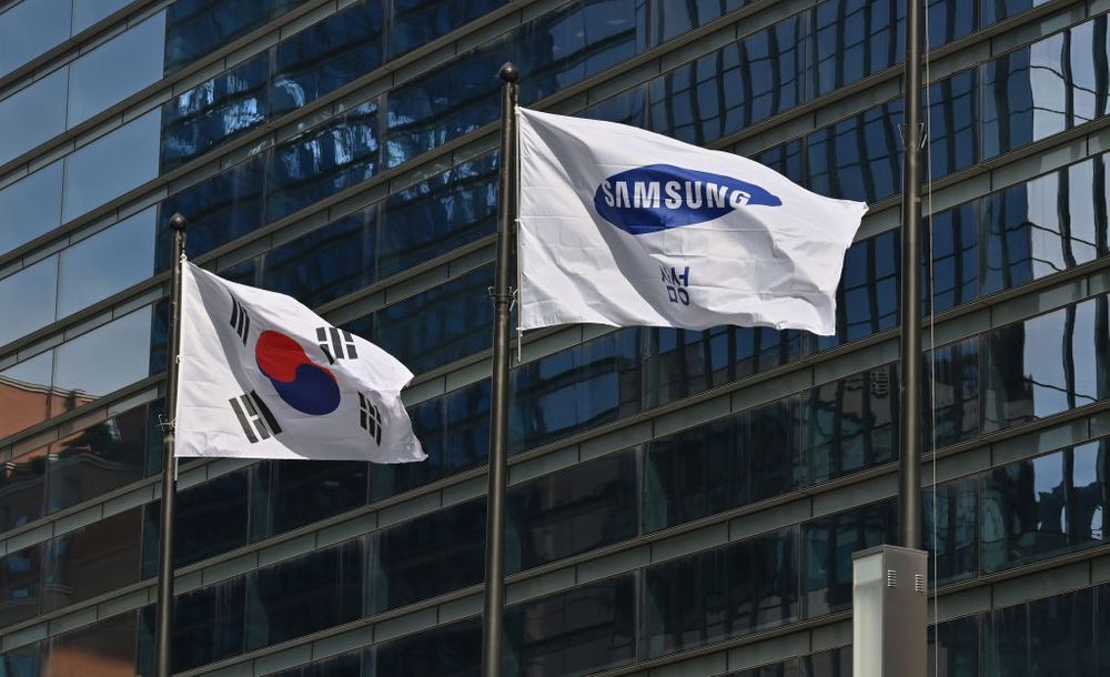 Samsung and South Korea flags flying in front of corporate Samsung building
