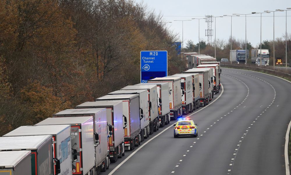 A line of freight lorries queueing along the highway waiting to access the Eurotunnel.