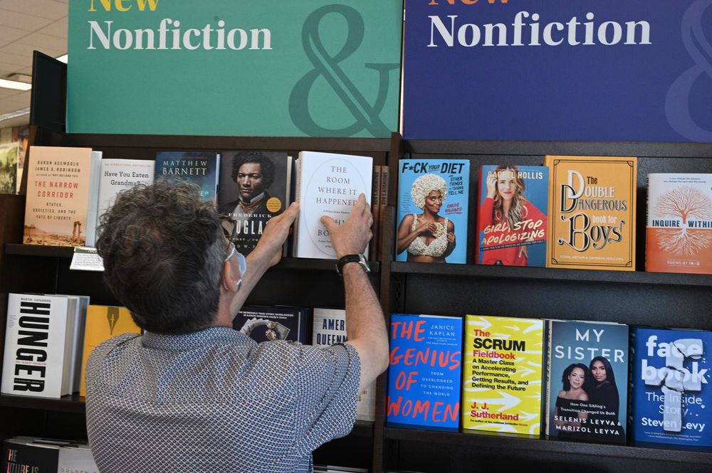 A shopper looks at a copy of the new book "The Room Where it Happened" b...