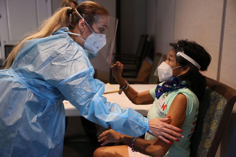 A woman receives the Covid-19 vaccine from an RN 