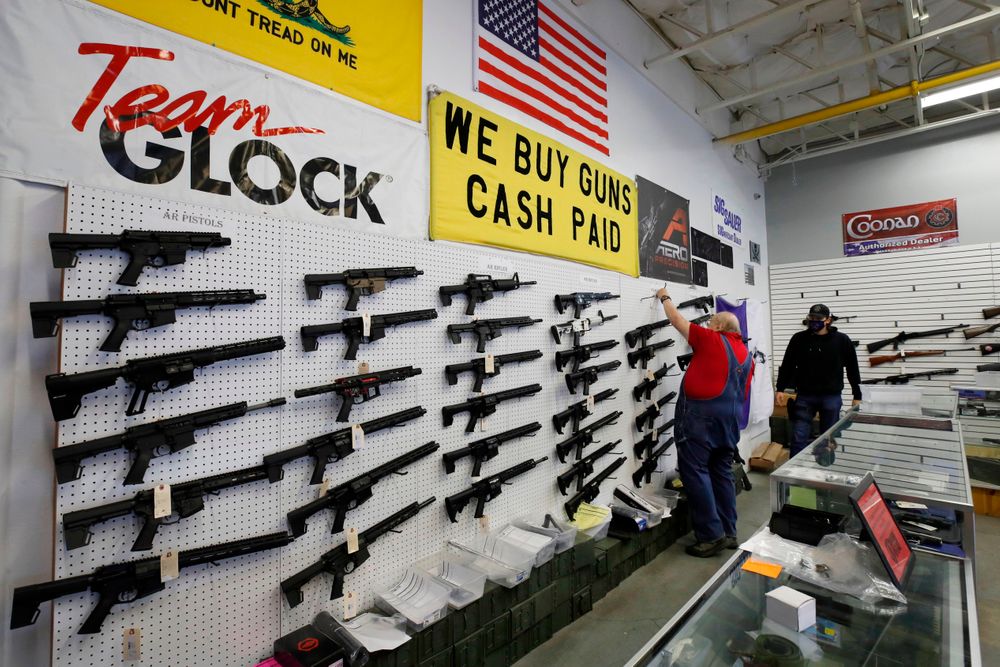 Workers arrange AR-15 style rifles on a wall that are for sale at Davids...